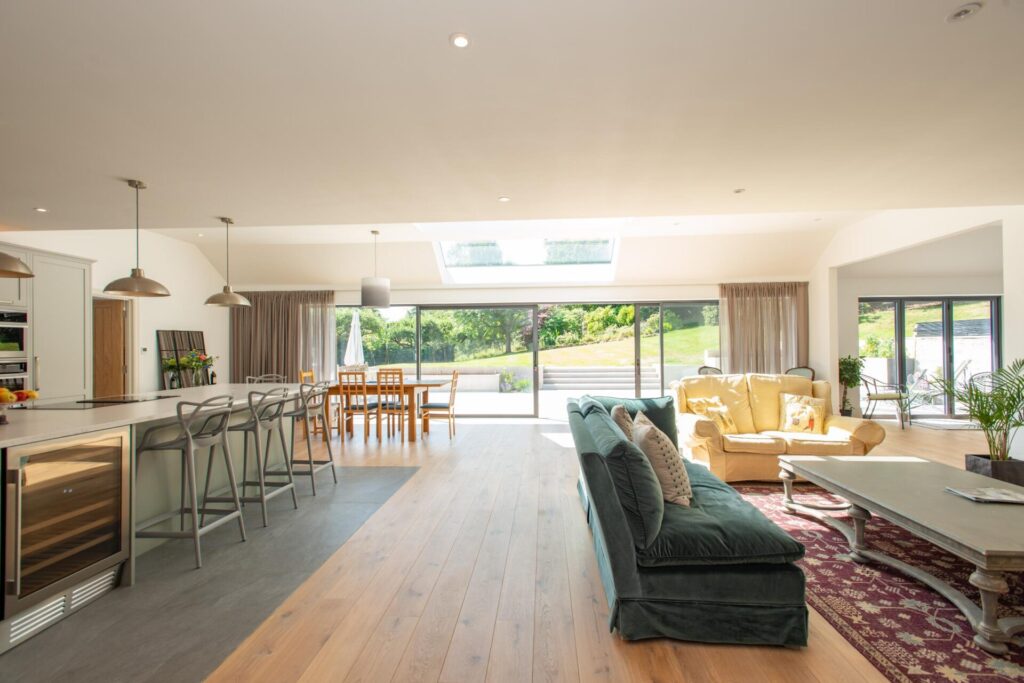 A Guide to Navigating Home Improvements in the New Year. Stunning open-plan kitchen and living space, with large glass doors leading out to the back garden. Lots of light pouring into the room.